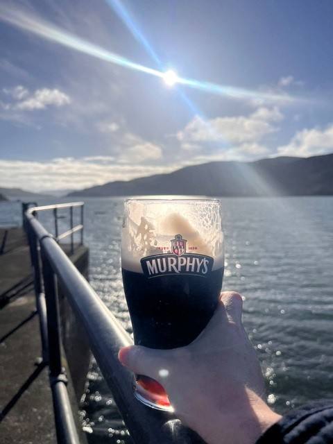 Cass holding a pint of Murphy's on Crook Pier