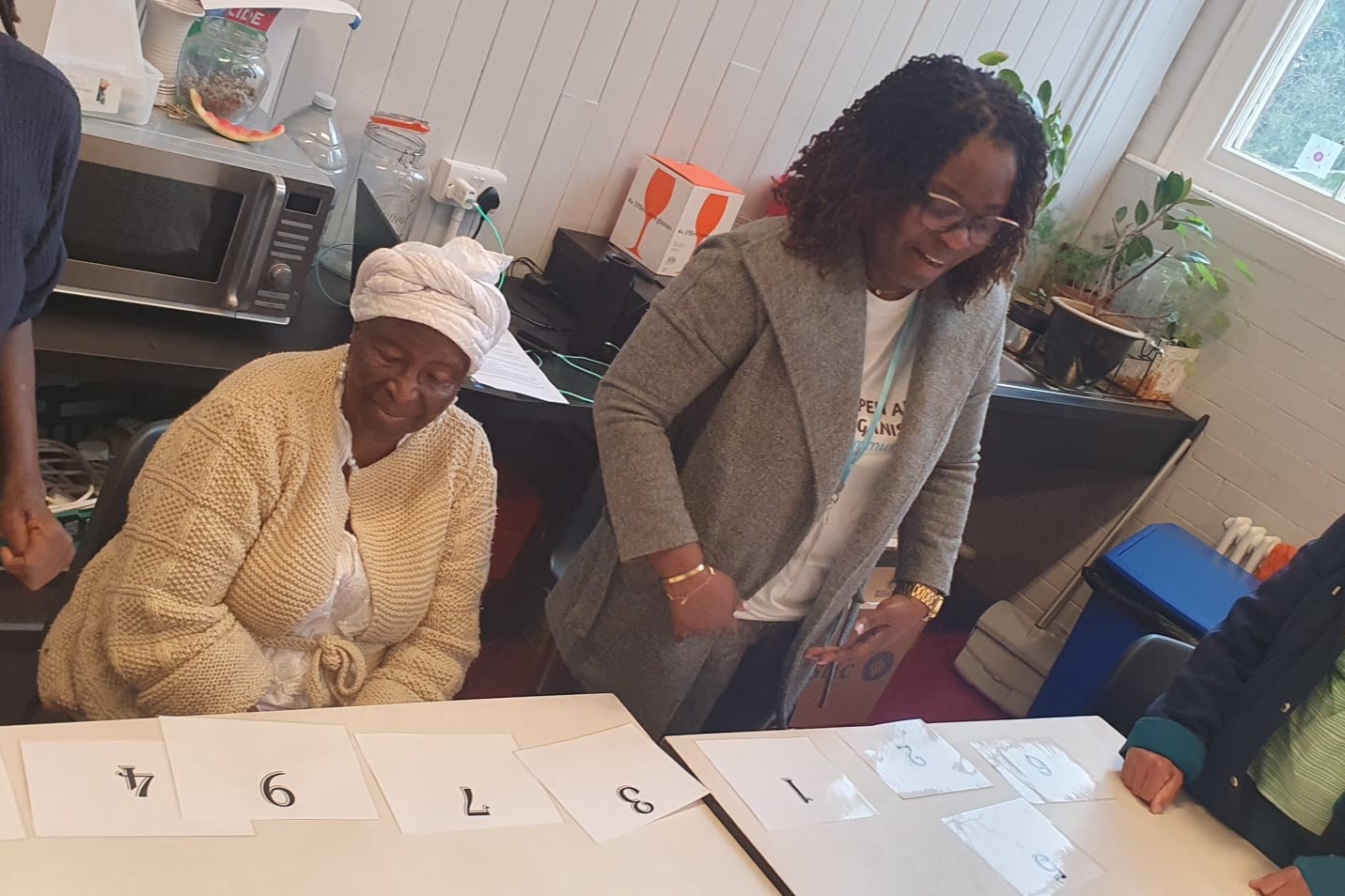 Two people at a table with numbered cards on it
