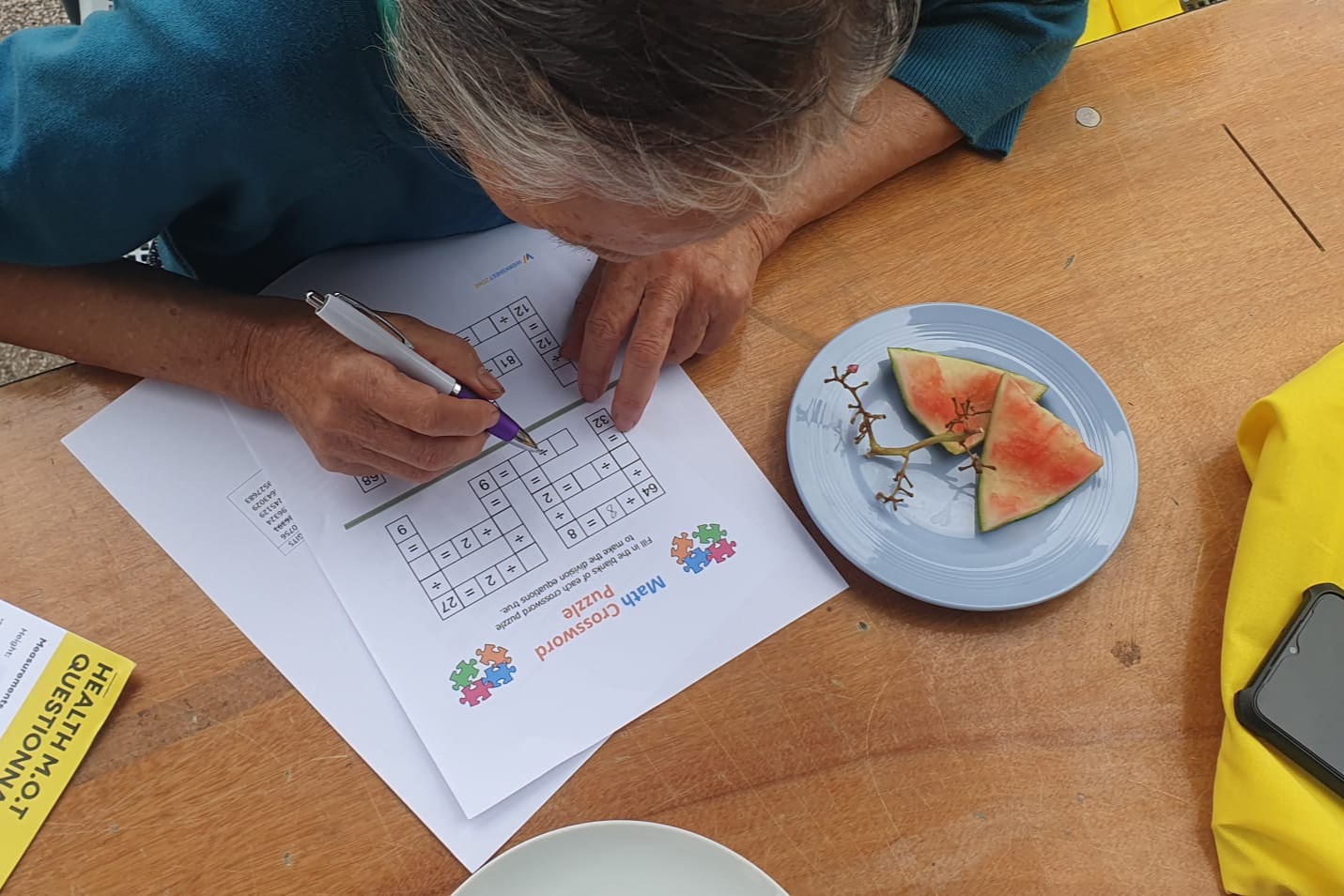 A person filling in a maths crossword puzzle