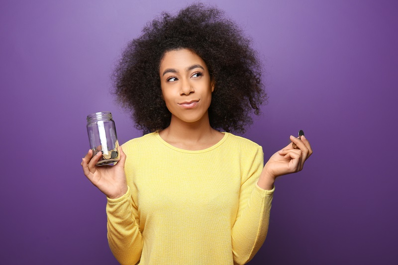 woman holding jar of coins