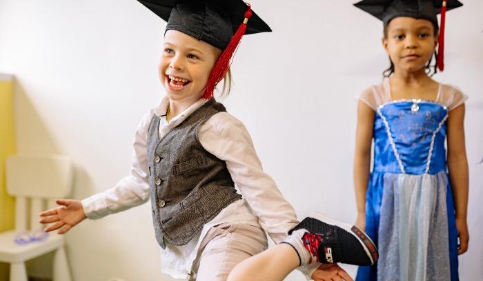 Children playing dress-up in graduation caps
