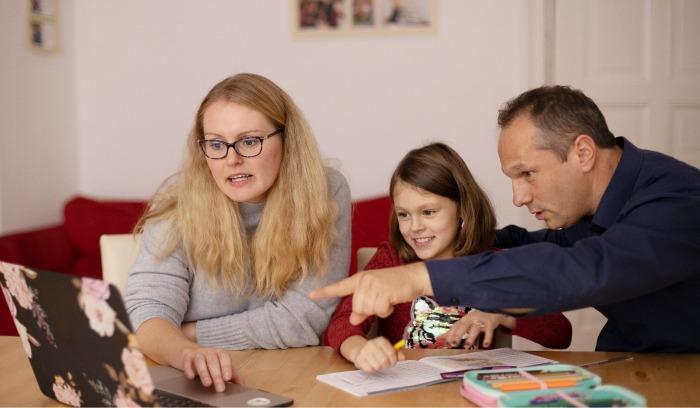 Parents sitting with their daughter to learn together on the computer