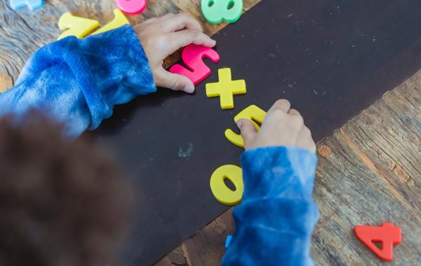 young child playing with plastic numbers