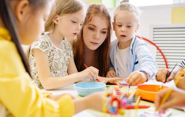 Young children doing arts and crafts with an adult