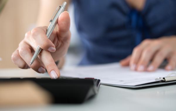 A person typing into a calculator