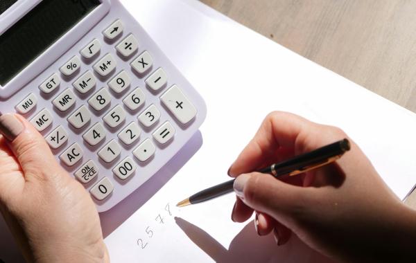 A person using a calculator and making notes