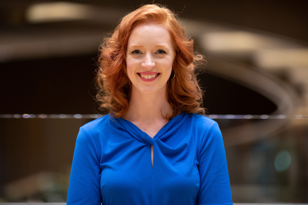 Head and shoulders photo of Iona, smiling, in blue blouse