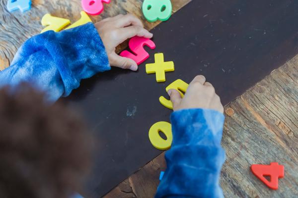 young child playing with plastic numbers