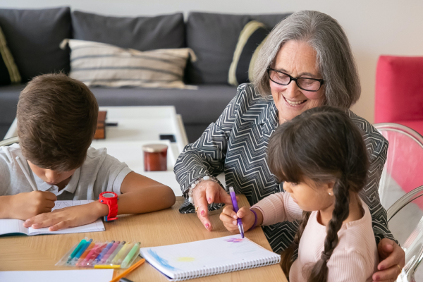 Older person helping children with homework