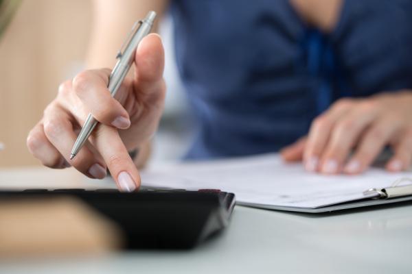 A person typing into a calculator