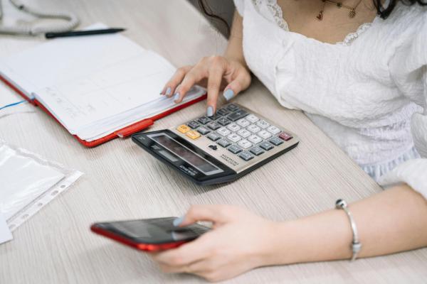 A person using a calculator and a mobile phone