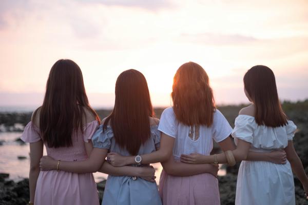 A view from behind of four women side by side looking into the distance