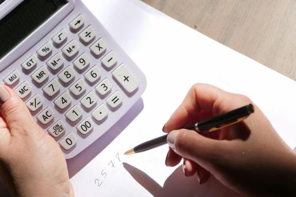 A person using a calculator and making notes